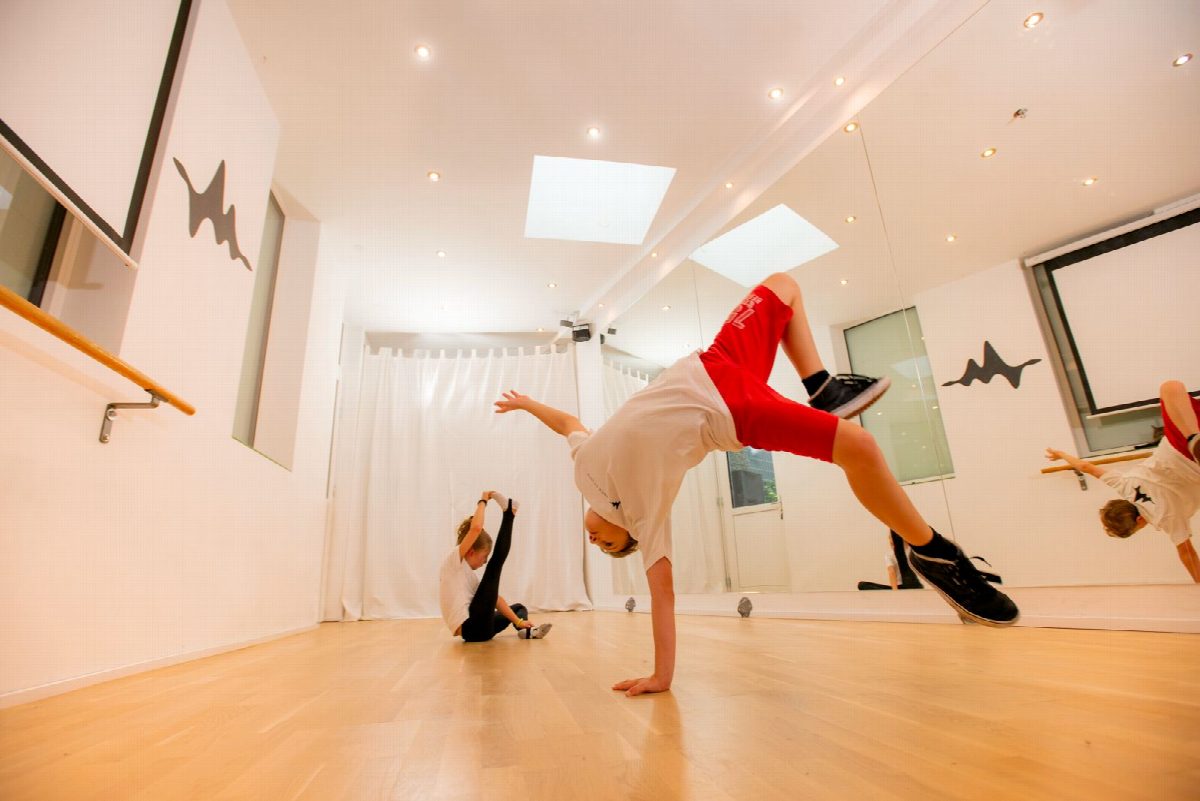 Ein Junge im Breakdance-Freeze auf einer Hand