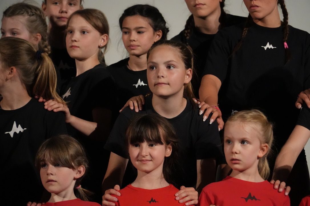 Kindergruppe in schwarzen und roten Studio-Shirts, dicht beieinander