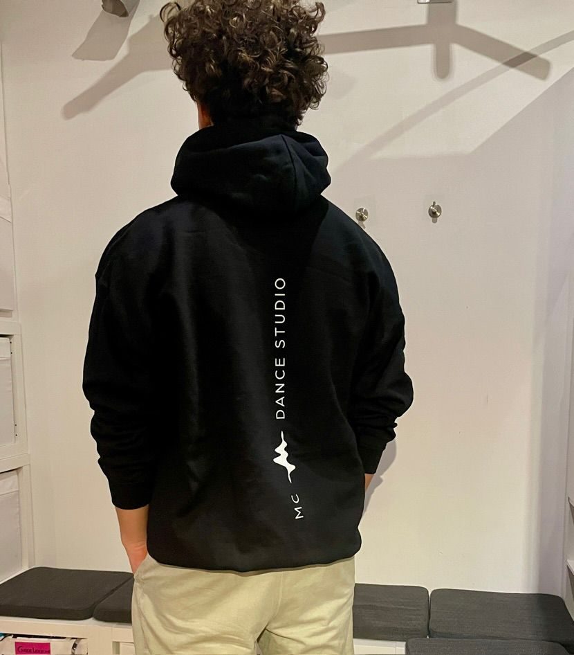 Rückenansicht eines schwarzen Studio-Hoodies mit senkrechtem Schriftzug