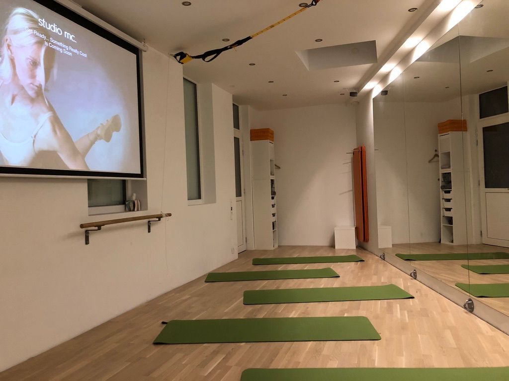 Der Studioraum mit ausgelegten Matten, Spiegelwand und Leinwand