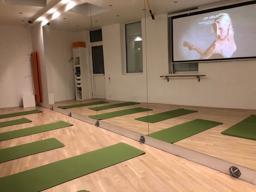 Der Studioraum mit Matten, Spiegelwand und Videowall